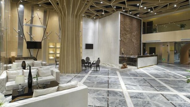 A spacious lobby with a modern design, featuring a marble floor, white sofas, and a central seating area. - Huangcheng Imperial Garden Hotel (Hefei)
