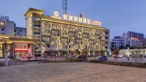 A hotel with a modern facade featuring geometric patterns and a prominent entrance with a fountain. - Huangcheng Imperial Garden Hotel (Hefei)