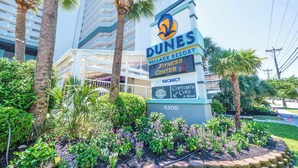 A Dunes Village Resort sign with a fitness center, a vacant room, and a Captain's Cafe & Bar. - Beachfront condo with pools & hot tub (Myrtle Beach)