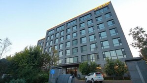 A modern building with a flat roof and a large entrance. - Jujian Hotel (Harbin)
