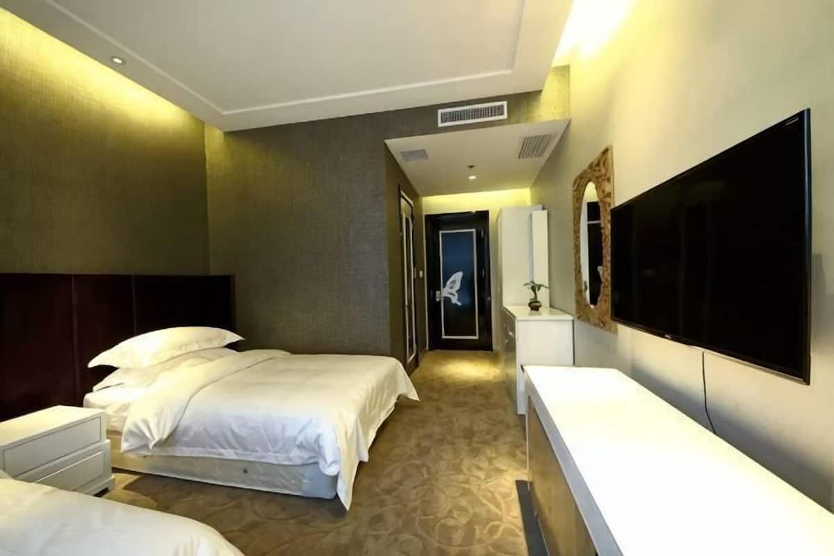 A hotel room with a bed, a desk, a TV, and a bathroom.