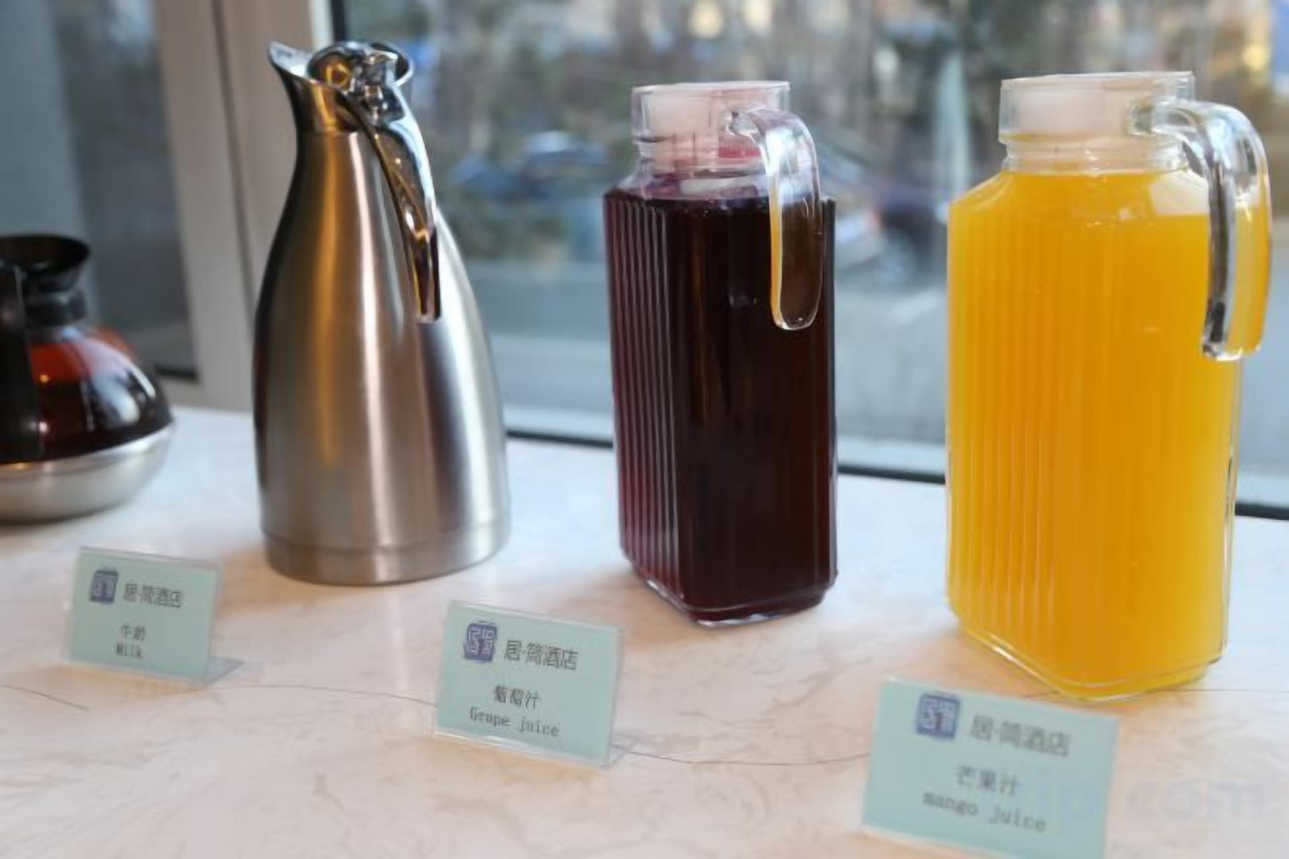 Three beverage dispensers with labels on a table.