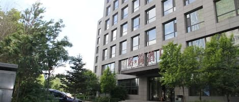 A multi-story building with a modern architectural design, featuring a series of windows and a visible entrance.