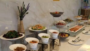A buffet setup with various dishes and utensils. - Jujian Hotel (Harbin)