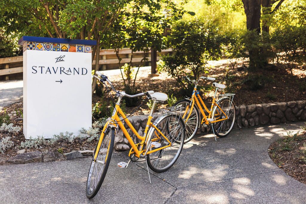 A sign for 'The Stavrand' with two yellow bicycles parked beside it.