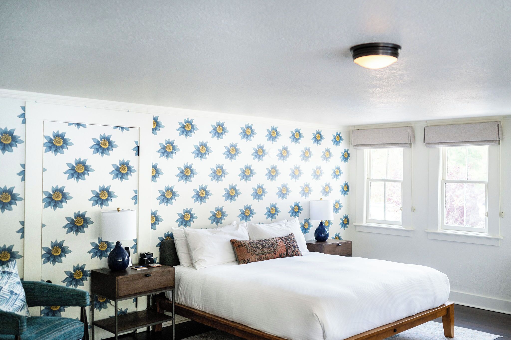 A bedroom with a bed, nightstands, a chair, and a dresser.