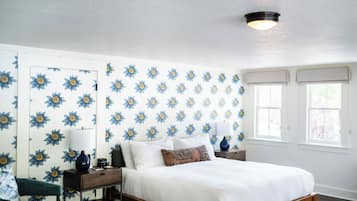 A bedroom with a bed, nightstands, a chair, and a dresser.