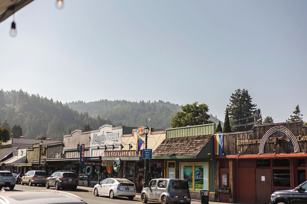 A street view with various shops, including a sports store and a Rainbow Cafe.