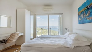 A bedroom with a bed, a desk, a chair, and a large window with a view. - Modern 5-BR Villa with Pool, Jacuzzi & Sea View (Ičići)
