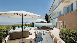 A poolside area with lounge chairs, umbrellas, and a hot tub. - Modern 5-BR Villa with Pool, Jacuzzi & Sea View (Ičići)
