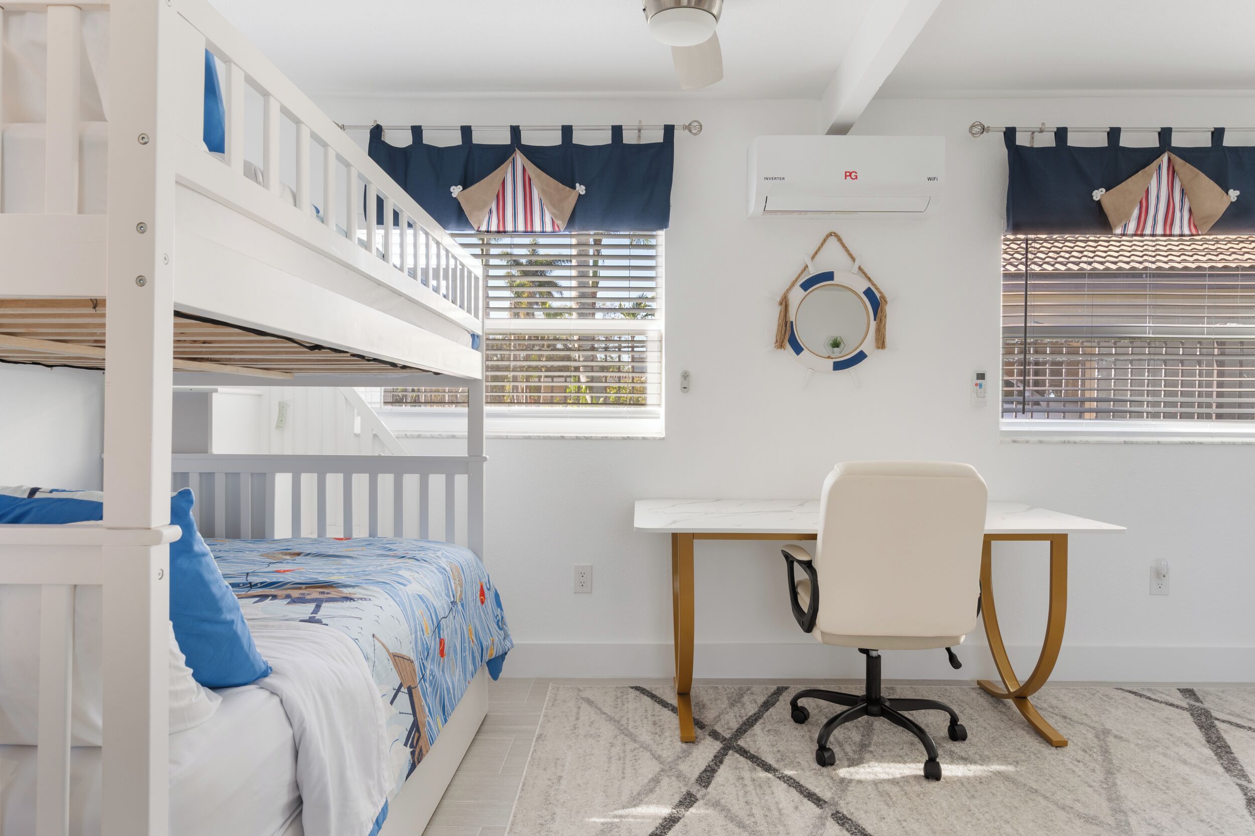 A child's bedroom with bunk beds, a desk, and a chair.