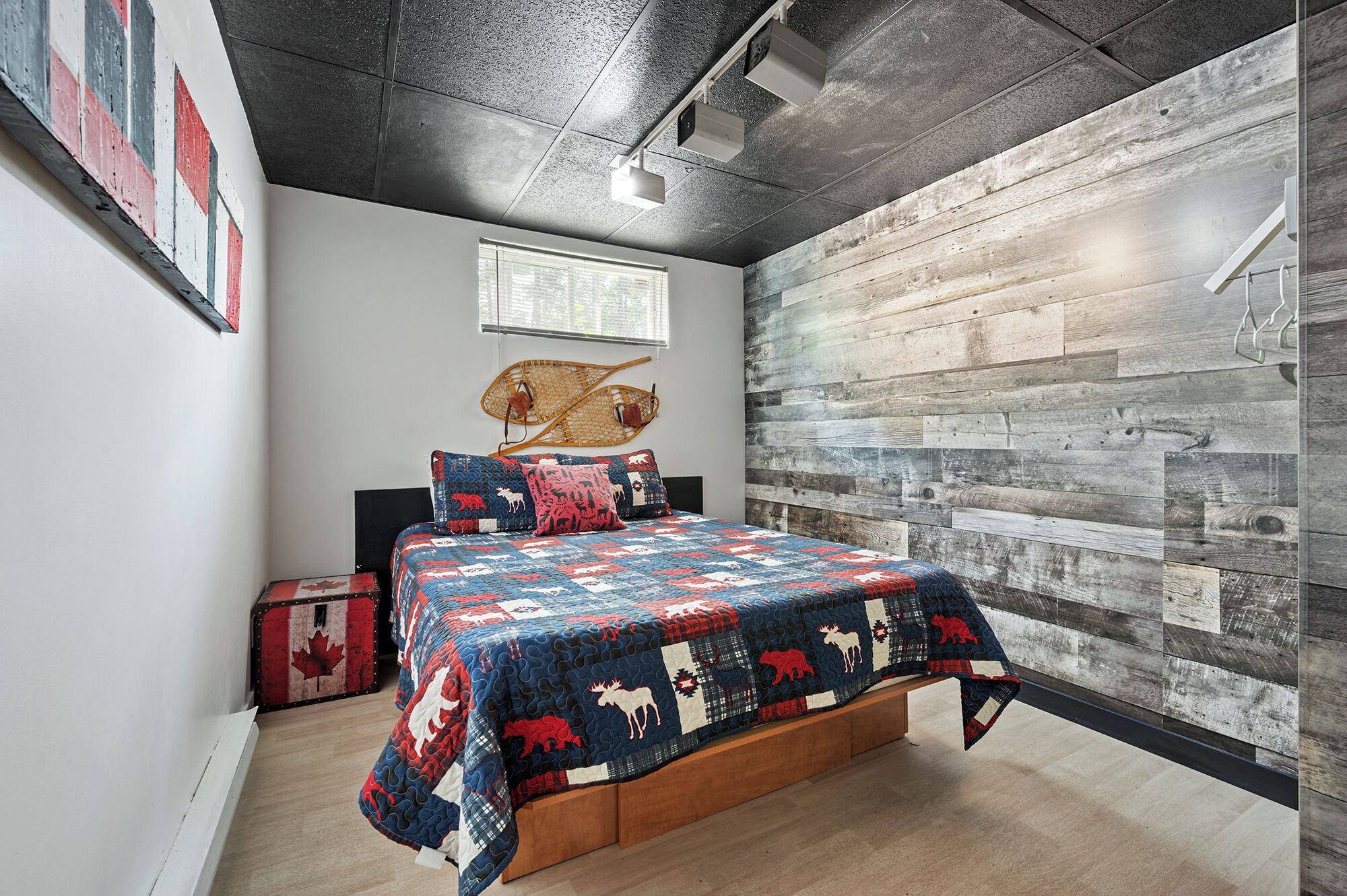 A bedroom with a wooden bed, a window, and a rustic wall.
