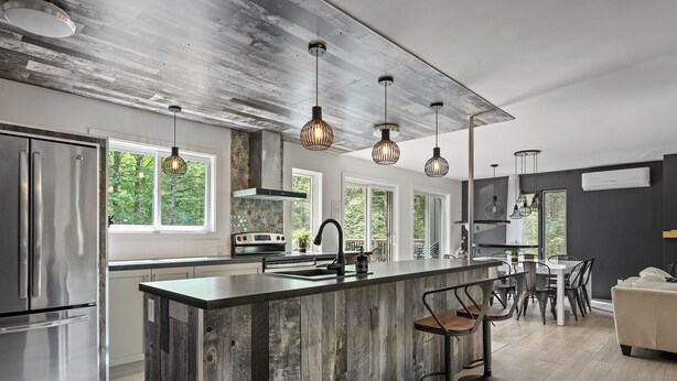 A modern kitchen with a large island, stainless steel appliances, and pendant lighting. - Le Panaché - Cottage to rent in Stoneham (CITQ: 298070) (Stoneham-et-Tewkesbury)