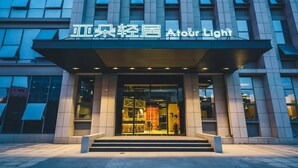 A modern hotel entrance with a glass facade and a sign that reads "Atour Light". - Atour Light (Hangzhou)