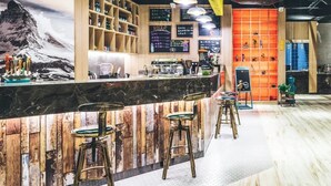 A bar area with wooden bar counters, stools, and shelves with bottles. - Atour Light (Hangzhou)