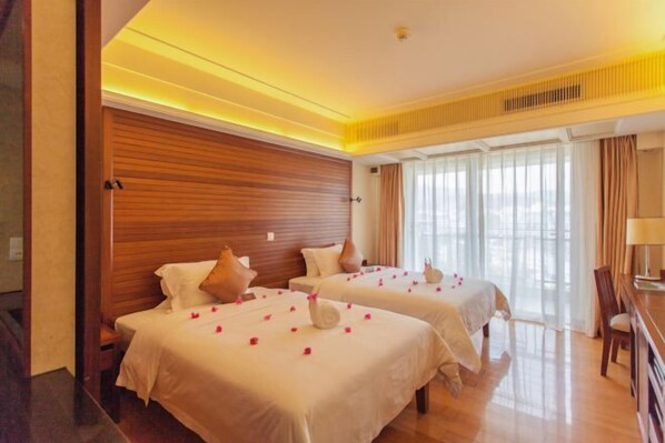 A hotel room with two beds, wooden headboards, and a large window with curtains. - Zhujiang Crystal Hotel (Wuzhishan)