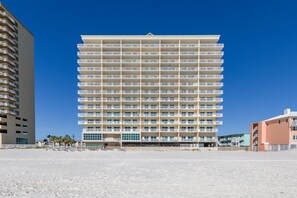 A multi-story hotel with a uniform facade, balconies, and a flat roof.