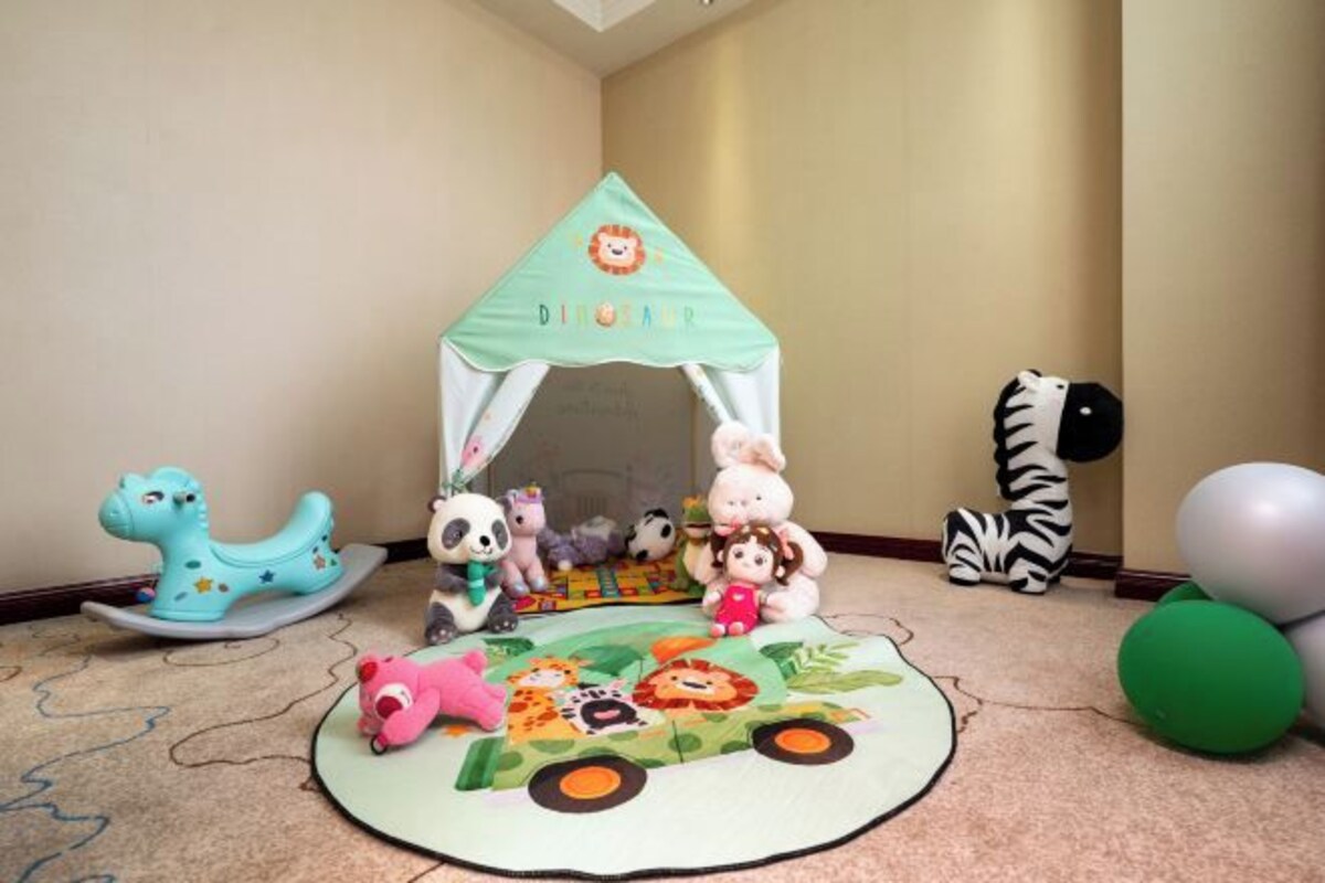A children's play area with a tent, plush toys, and a play mat.