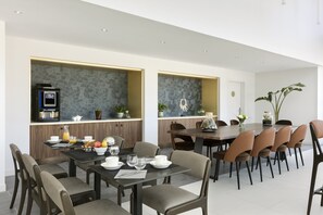 Una zona de menjador moderna amb un taulell de cuina, seients i vista de la sala.