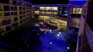 A multi-story hotel with a central courtyard, outdoor seating area, and a pool. - Fuquan Grand Hotel (Pingdingshan)