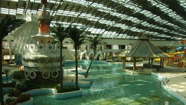 An indoor water park with a central pool, palm trees, and a gazebo. - Fuquan Grand Hotel (Pingdingshan)