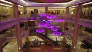 A multi-level atrium with a central escalator surrounded by columns and decorative elements. - Fuquan Grand Hotel (Pingdingshan)