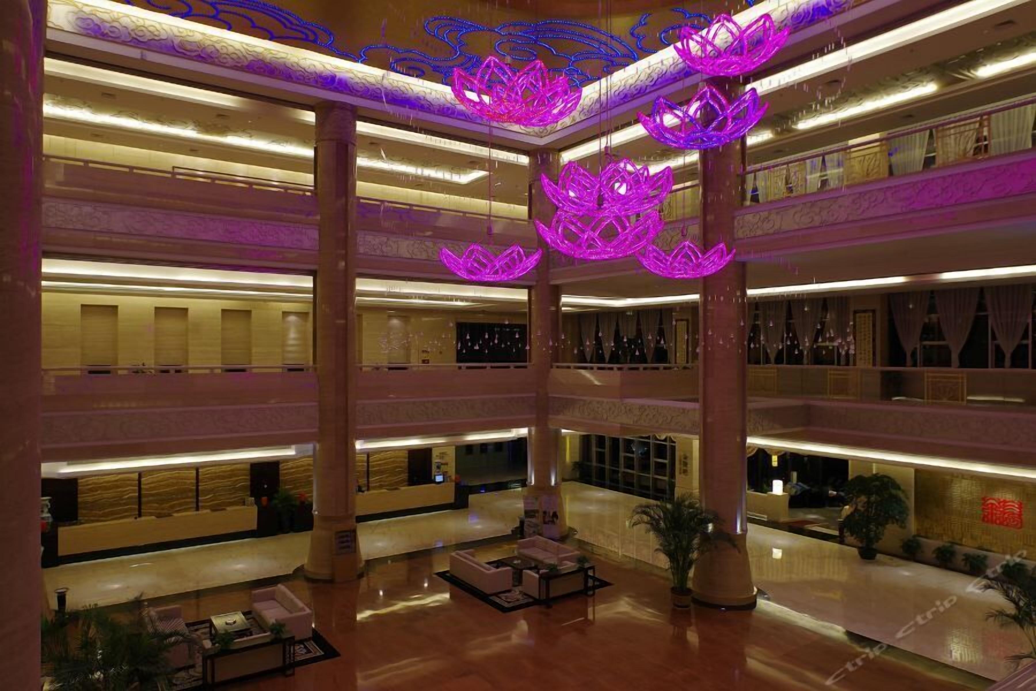 A multi-level hotel lobby with a central atrium, multiple floors, and a reception desk.