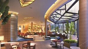 A modern hotel lobby with a central seating area, a pool, and large windows offering views of the outdoors. - Fuquan Grand Hotel (Pingdingshan)