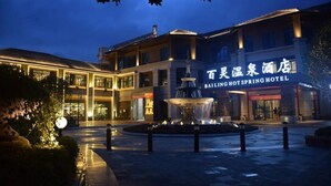 A hotel with a fountain in the courtyard, illuminated by lights. - Bailing Hot Spring Hotel (Anshun)