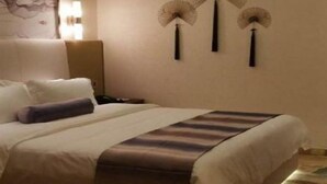 A hotel room with a large bed, a nightstand, and three wall-mounted fans. - Golden Orange Smart Hotel (Shenzhen)
