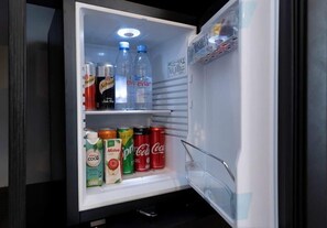 A refrigerator with shelves stocked with beverages including cans and bottles. - Surestay Hotel by Best Western Vientiane (Vientiane)