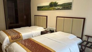 A hotel room with two beds, a wardrobe, and a painting on the wall. - Bingtuan Building (Beijing)