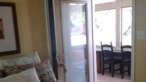Un dormitorio con cama, una puerta que da a un balcón y un cuadro en la pared.