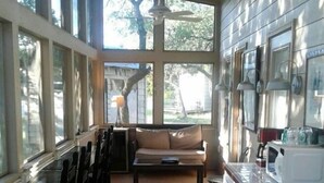 Una cocina amplia con ventanas grandes, un comedor con sillas, un sofá y una encimera con electrodomésticos.