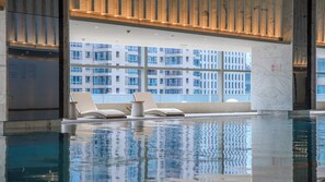 An indoor swimming pool with two lounge chairs and a marble column. - Intercontinental Xi an North (Xi'an)