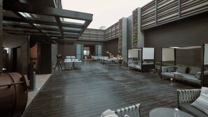 Un patio al aire libre con piso de madera, mobiliario y un telescopio.