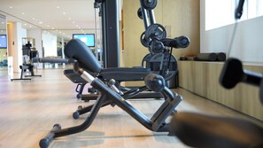 A gym with exercise equipment, a television screen, and a wooden floor. - Intercontinental Xi an North (Xi'an)