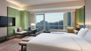 A modern hotel room with a large bed, seating area, and a city view. - Intercontinental Xi an North (Xi'an)