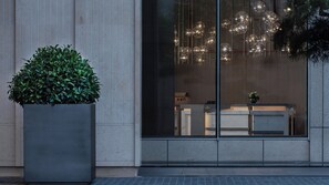 A modern building facade with a large potted plant, reflective glass windows, and a visible reception desk. - Intercontinental Xi an North (Xi'an)