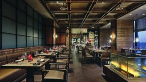 A restaurant with a long counter, booths, and a bar area. - Intercontinental Xi an North (Xi'an)