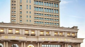 A multi-story hotel with a classic architectural design, featuring a prominent entrance with illuminated signage. - Friend Hotel Shanghai (Shanghai)