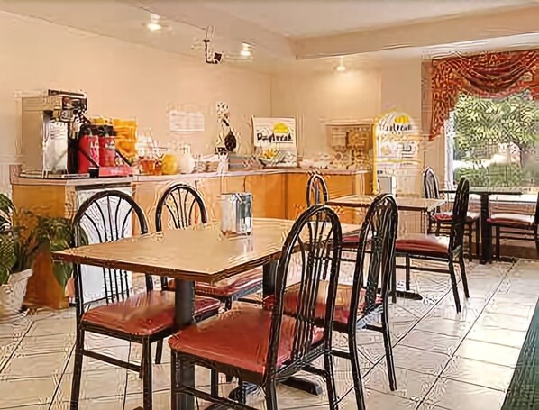 A restaurant with a counter, chairs, and tables. - Days Inn by Wyndham Ridgeland South Carolina (Ridgeland)