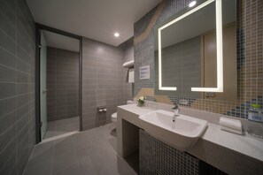 A modern bathroom with a large mirror, a sink, and a shower area. - Holiday INN Express Qingdao Innovation Park (Qingdao)