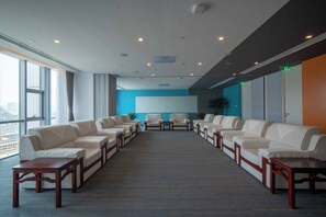 A conference room with a long table, multiple chairs, and a large screen. - Holiday INN Express Qingdao Innovation Park (Qingdao)