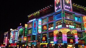 A brightly lit building with multiple neon signs, including a prominent McDonald's sign. - Lavande Hotel (Guangzhou)
