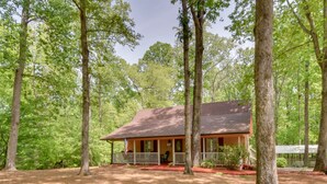 A cabin surrounded by tall trees in a forest. - ‘The Lake Place’ Cabin w/ Golf Cart & Free Kayaks! (Lavonia)