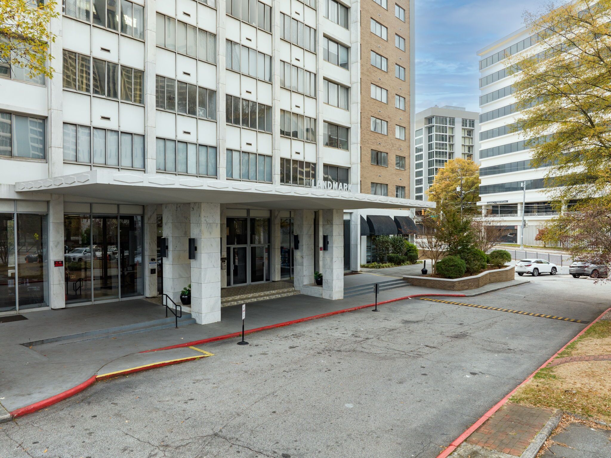 A modern hotel with a white facade, large windows, and a prominent entrance.