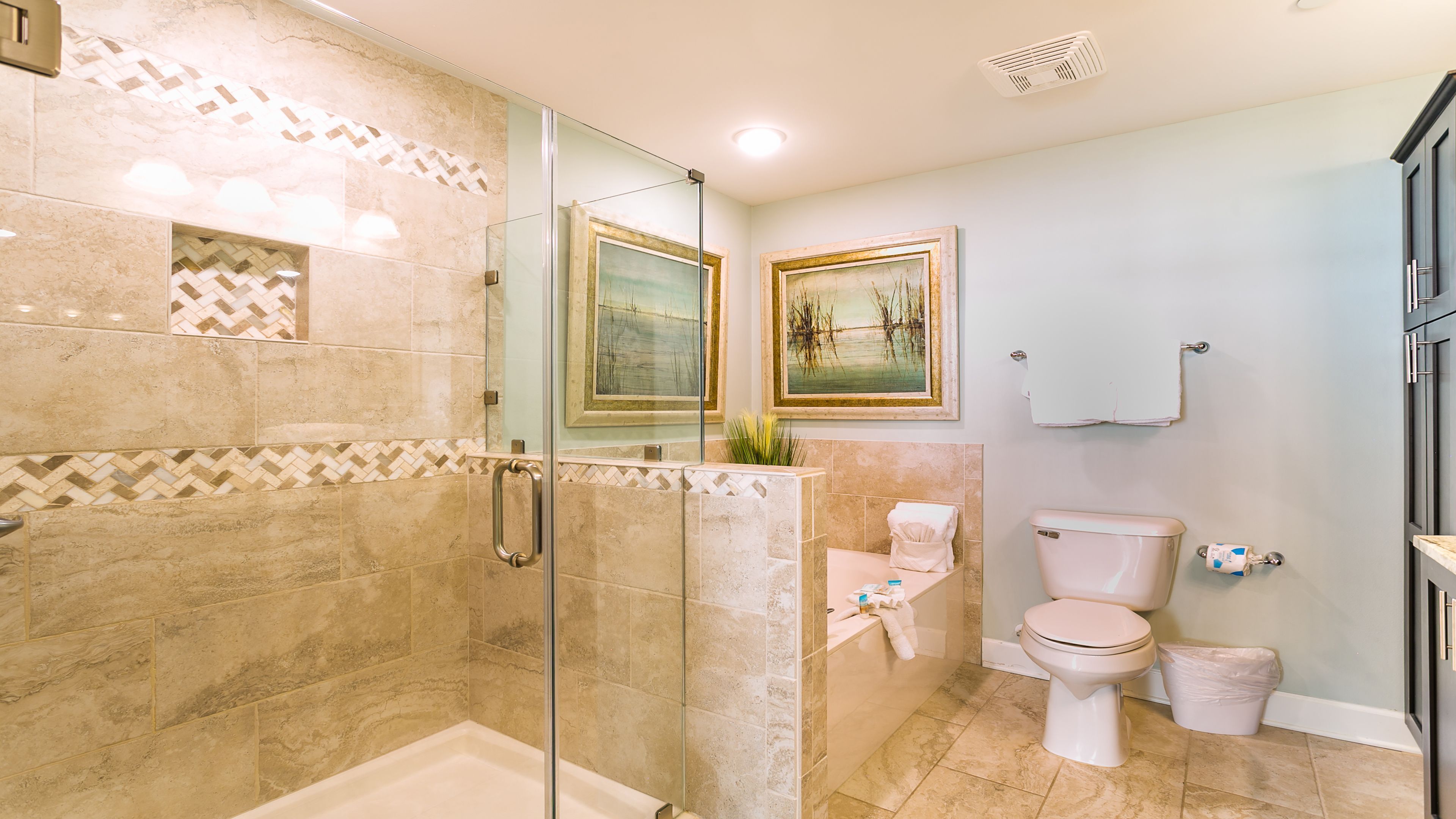 A modern bathroom with a glass-enclosed shower, a toilet, and a sink.