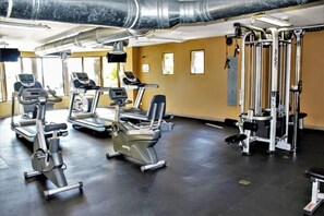 Ein Fitnessstudio mit Laufbändern, Crosstrainern und Gewichten.
