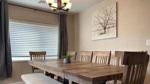 A dining area with a wooden table and chairs, a bench, a potted plant, and a painting on the wall. - Cozy Flagstaff Home w/ Outdoor Fire Place (Flagstaff)